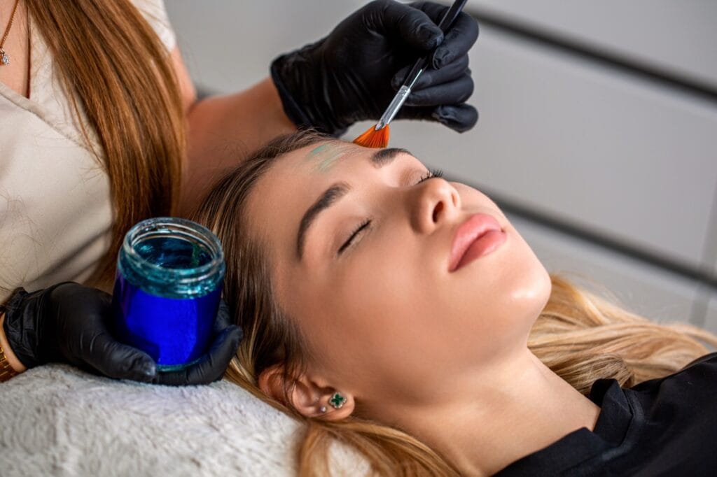 Dermatologist applying a chemical peel to a woman's face